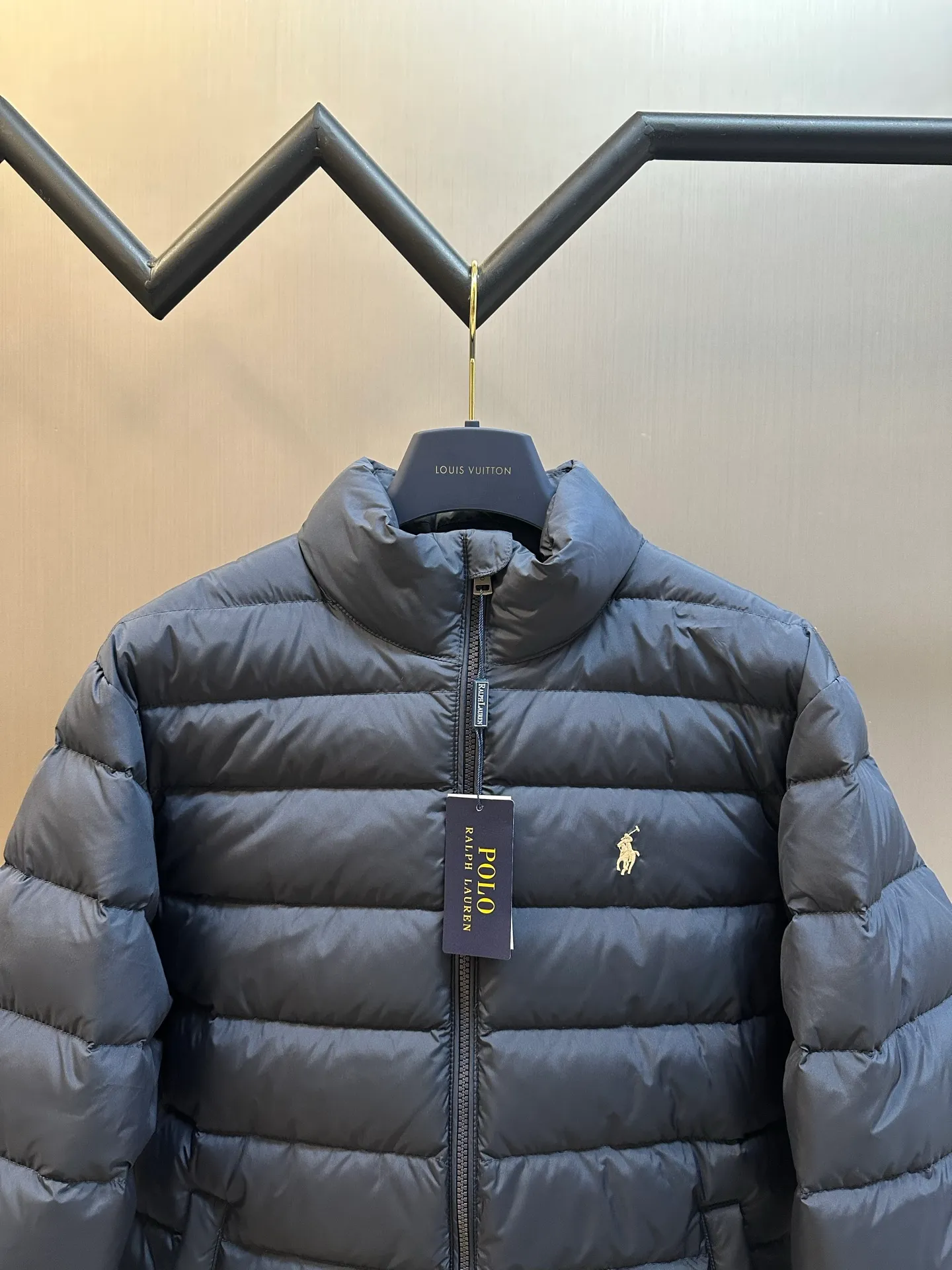 P890 Ralph Lauren lightweight down jacket. The nylon fabric has good windproof and waterproof properties, which can effectively block the intrusion of wind and rain from the outside and keep the inside dry. It is suitable for wearing in humid or rainy environments. The red label on the chest is made with an imported MECLO embroidery machine. The original pattern is scanned first, and then high-quality silk thread is used to make a pattern. The density effect is adjusted by continuous pattern making.  The zipper design is simple and elegant, easy to operate, and the closing design of the cuffs and hem effectively prevents cold wind from invading, improving the warmth and comfort of wearing. It uses 90 white duck down with a weight of 260g to ensure excellent thermal insulation performance. After strict screening and processing, the velvet is not easy to drill, ensuring durability. size: s m l xl